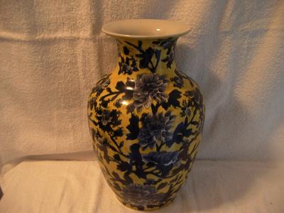 Yellow vase with blue flowers